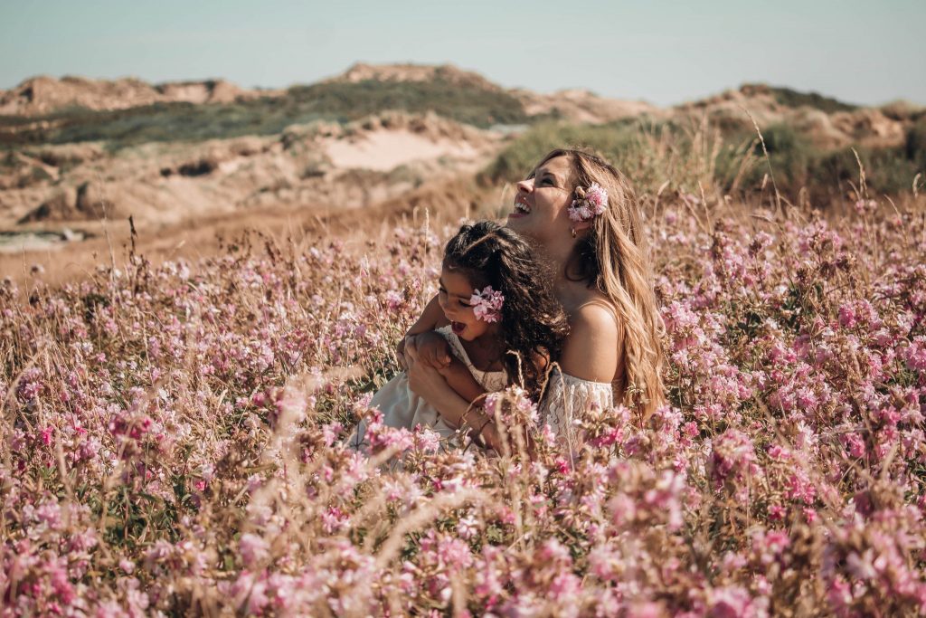 Portrait mère et fille fait à l'extérieur sur la côte de Wimereux dans un champs de fleurs roses.