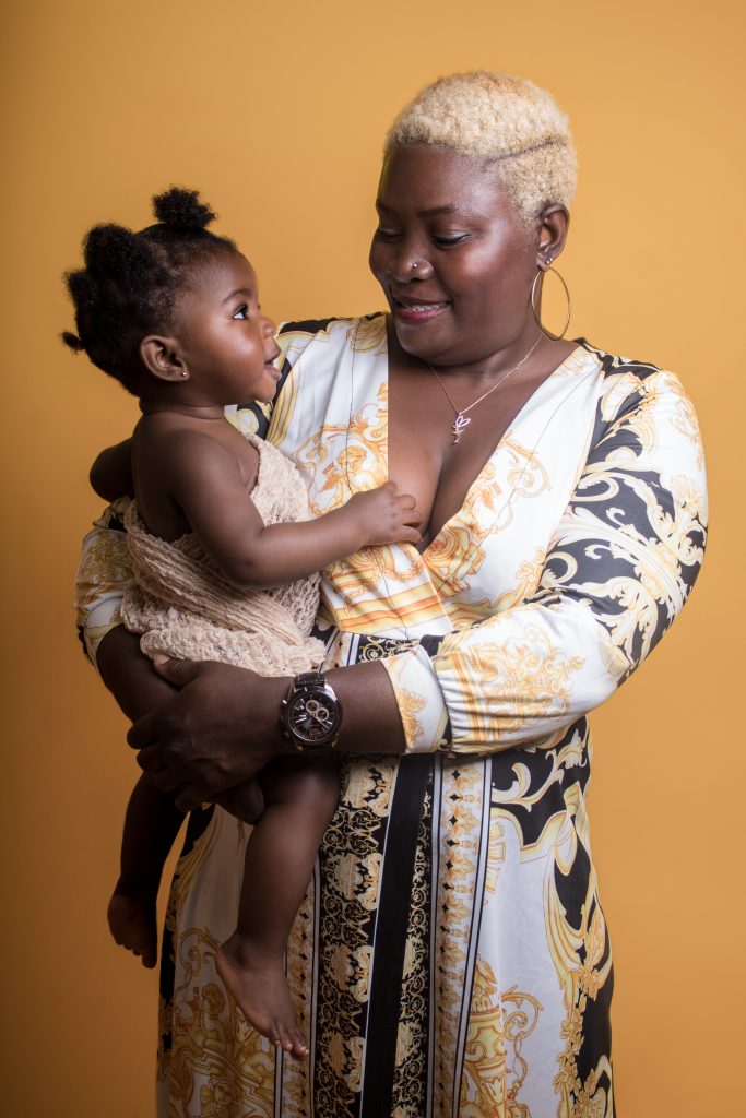 Séance photo bébé & moi au studio photo Ophélie Bajeux Photographie. Petite fille dans les bras de sa maman, sur fond jaune.